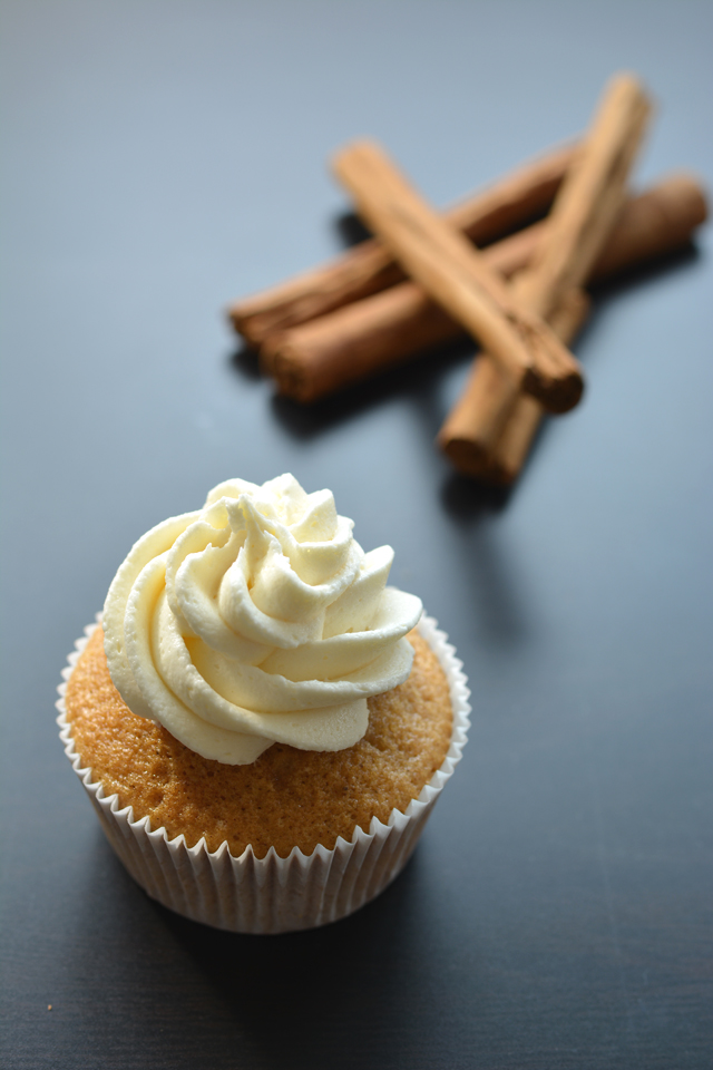 Close up view of cupcake with a swirl of butter cream and Cinnamon on the sides.