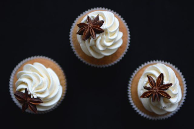 top view image of three chai tea spiced cupcakes adorned with buttercream frosting and garnished with a decorative piece of star anise