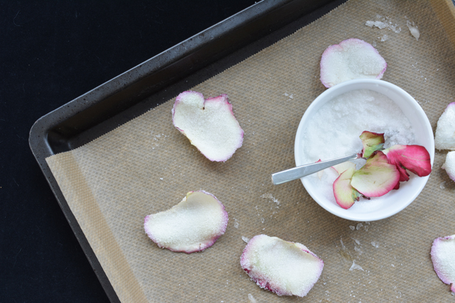 rose petals inside a bowl of sugar and on the sides