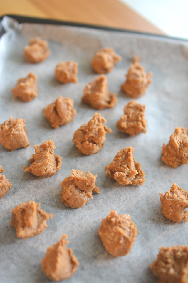 close-up image of tablespoon sized dollops of cookie dough on parchment paper