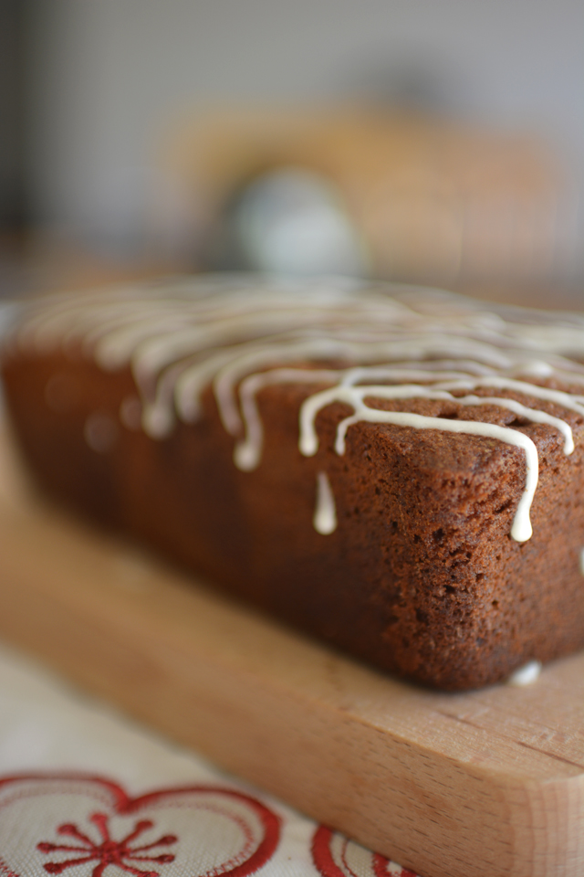 side view image of a single loaf of chocolate and ginger cake drizzled with glazed