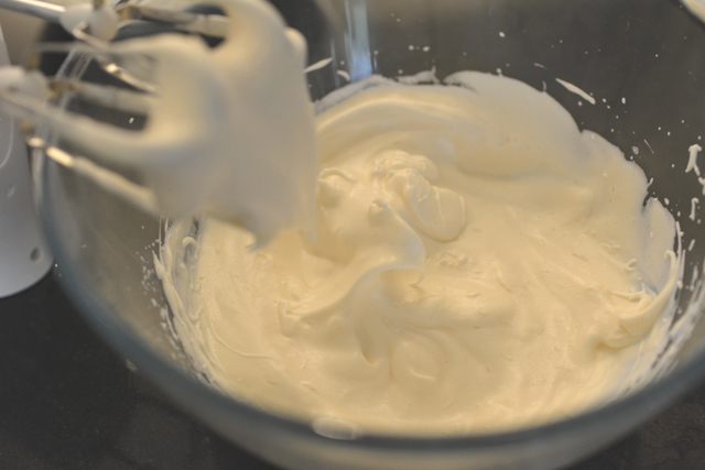 top down image of a bowl with stiff peak mixture of an icing