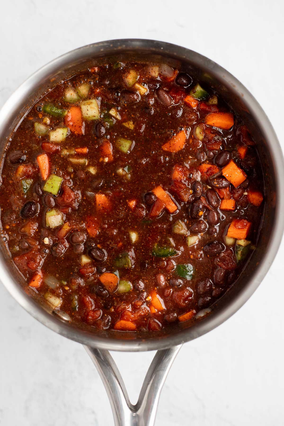 Black bean chili cooking in a saucepan.