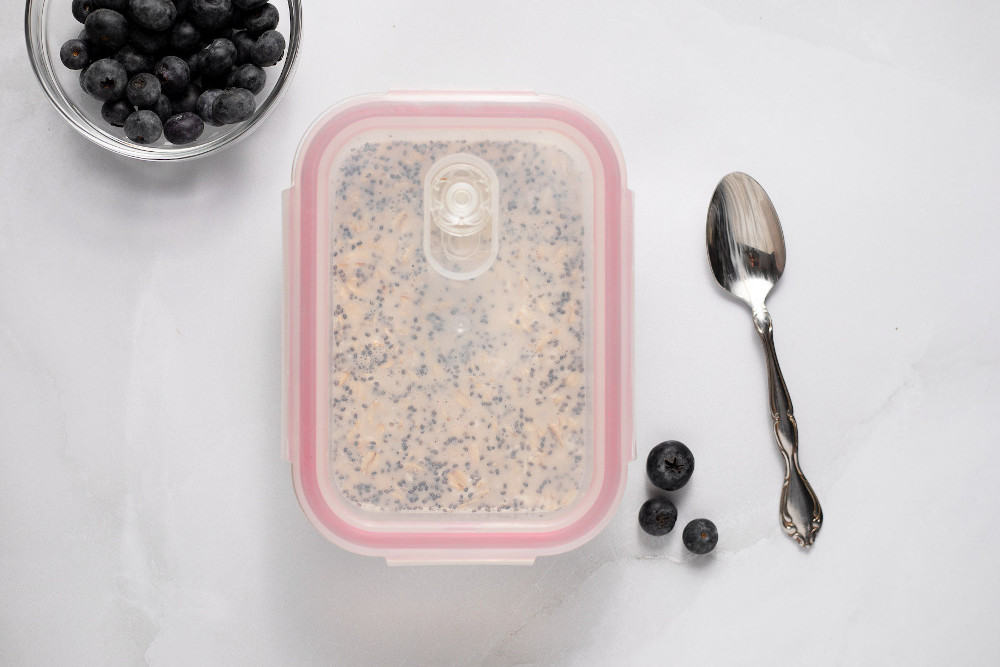 Blueberry Overnight Oats in a glass container with a lid on it, ready to go into the refrigerator.