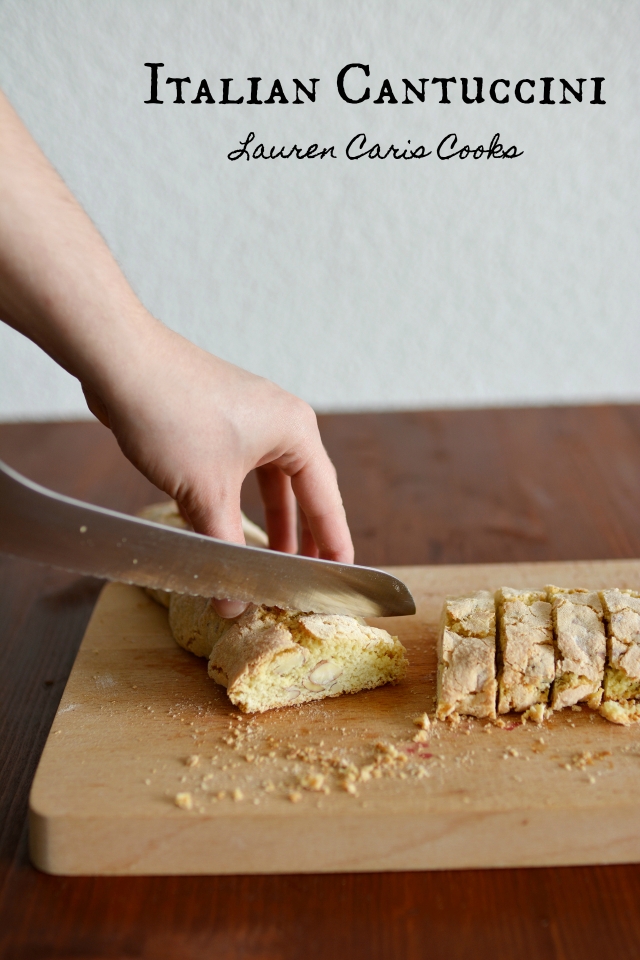 a hand slicing a cantuccini biscuit into bite-sized pieces