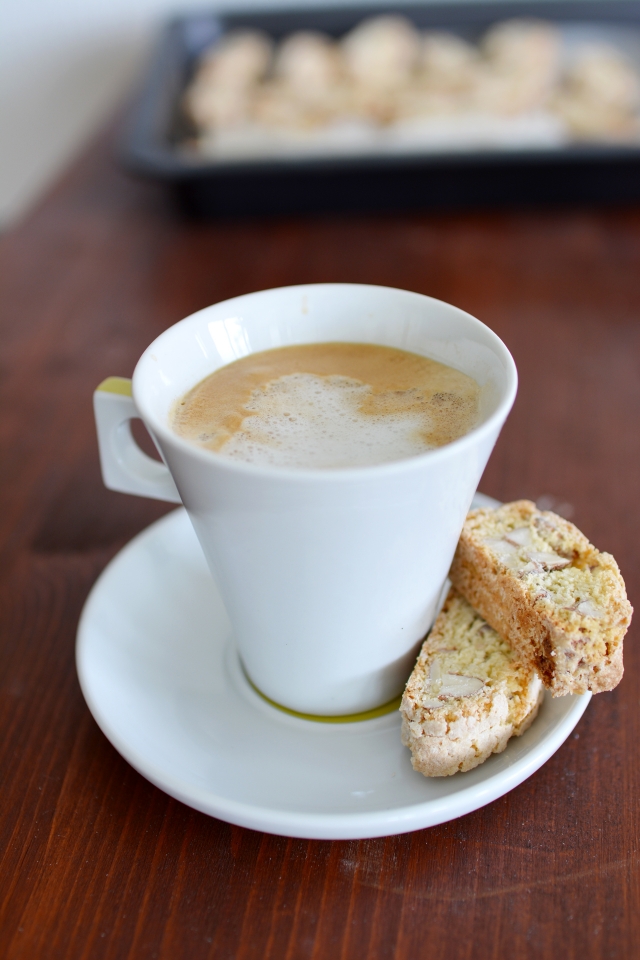 a cup of coffee paired with two slices of biscotti