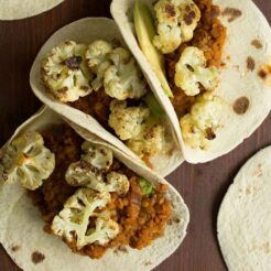 tacos filled with roasted cauliflower, spicy lentils, sultanas and avocado