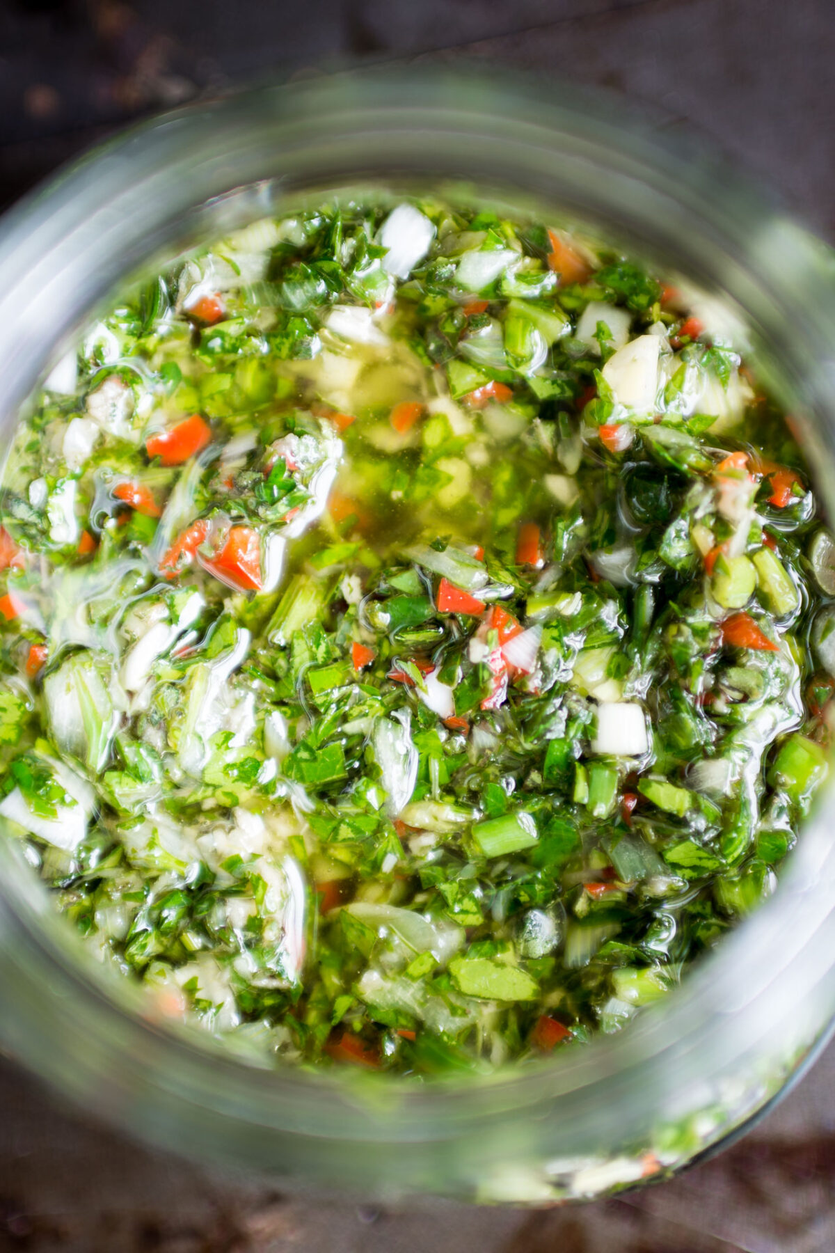 Overhead view of fresh Chimichurri sauce in a jar.