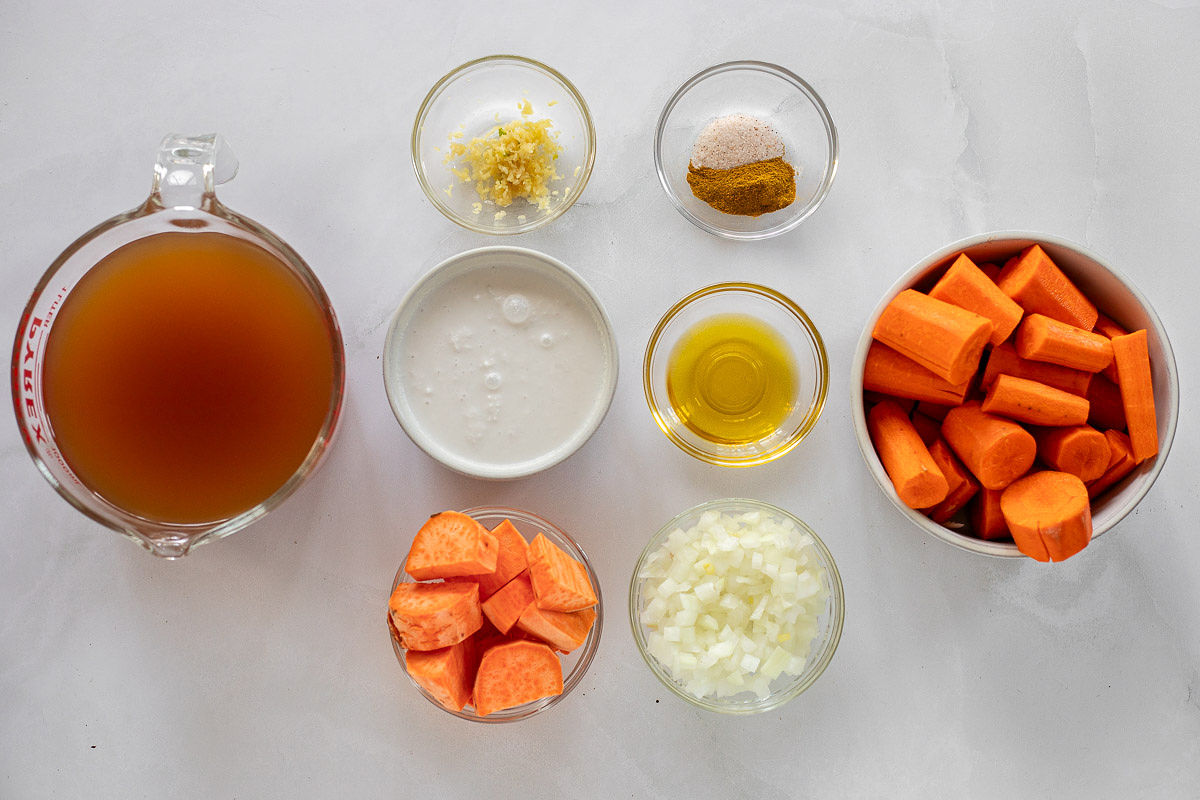 Bowls containing the ingredients needed to make coconut carrot soup.