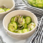 Cucumber salad with red onions, vinegar, and dill.