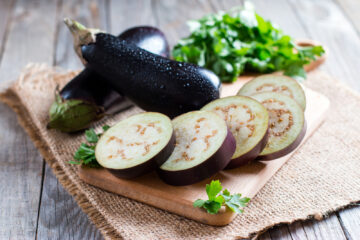 Slices of eggplant on a cutting board.