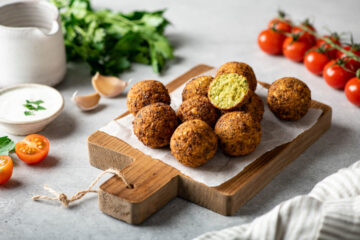 Falafel balls on a wooden cutting board.