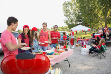 Friends grilling at a tailgate party on game day.