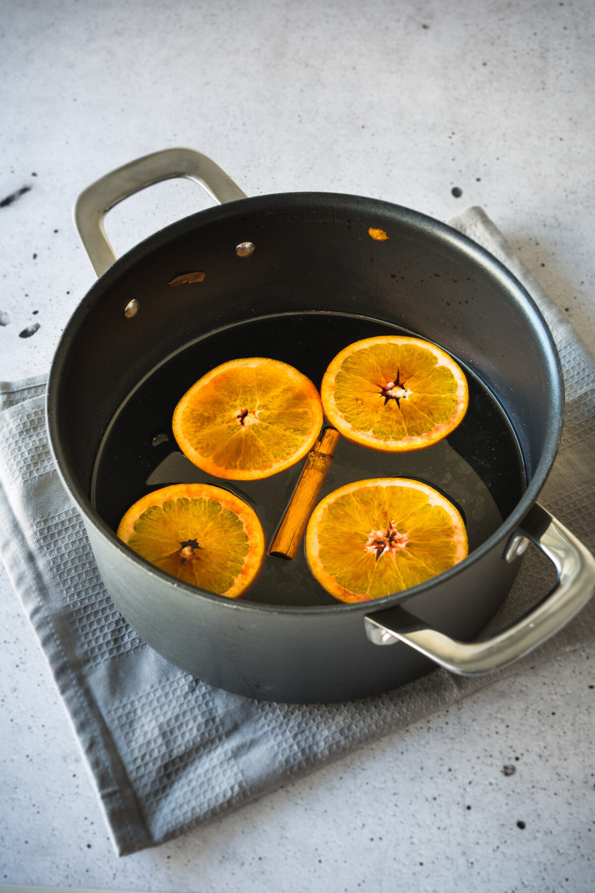 a pot containing german mulled wine with slices of lemon and cinnamon stick