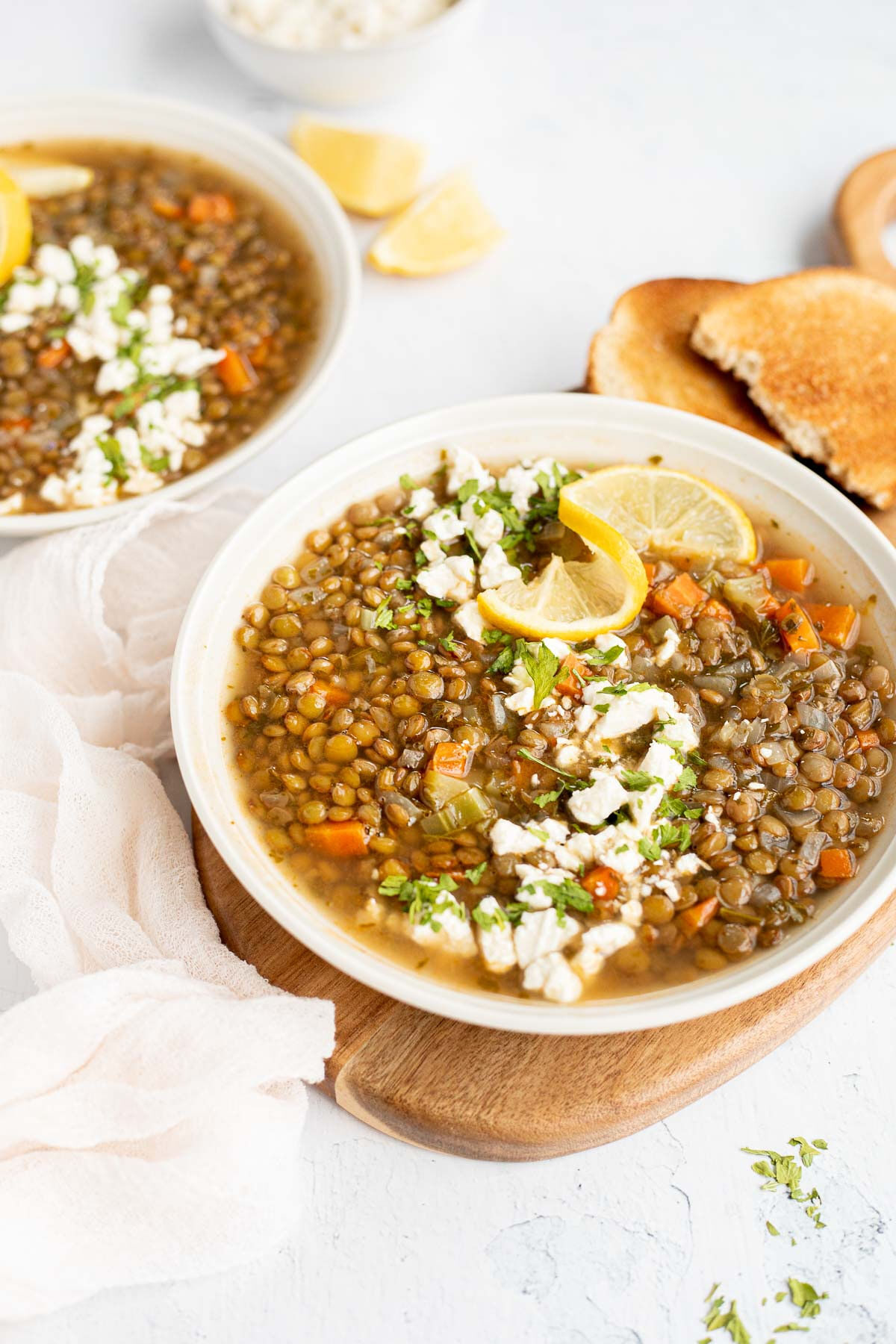 Side view of Greek Lentil Soup on a cutting board with toast.