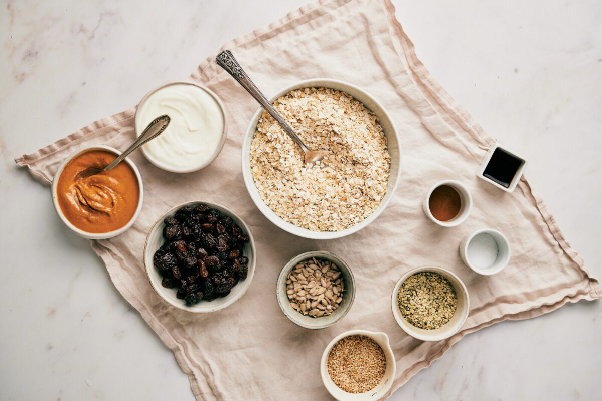 Ingredients for homemade granola bars on a piece of beige fabric.