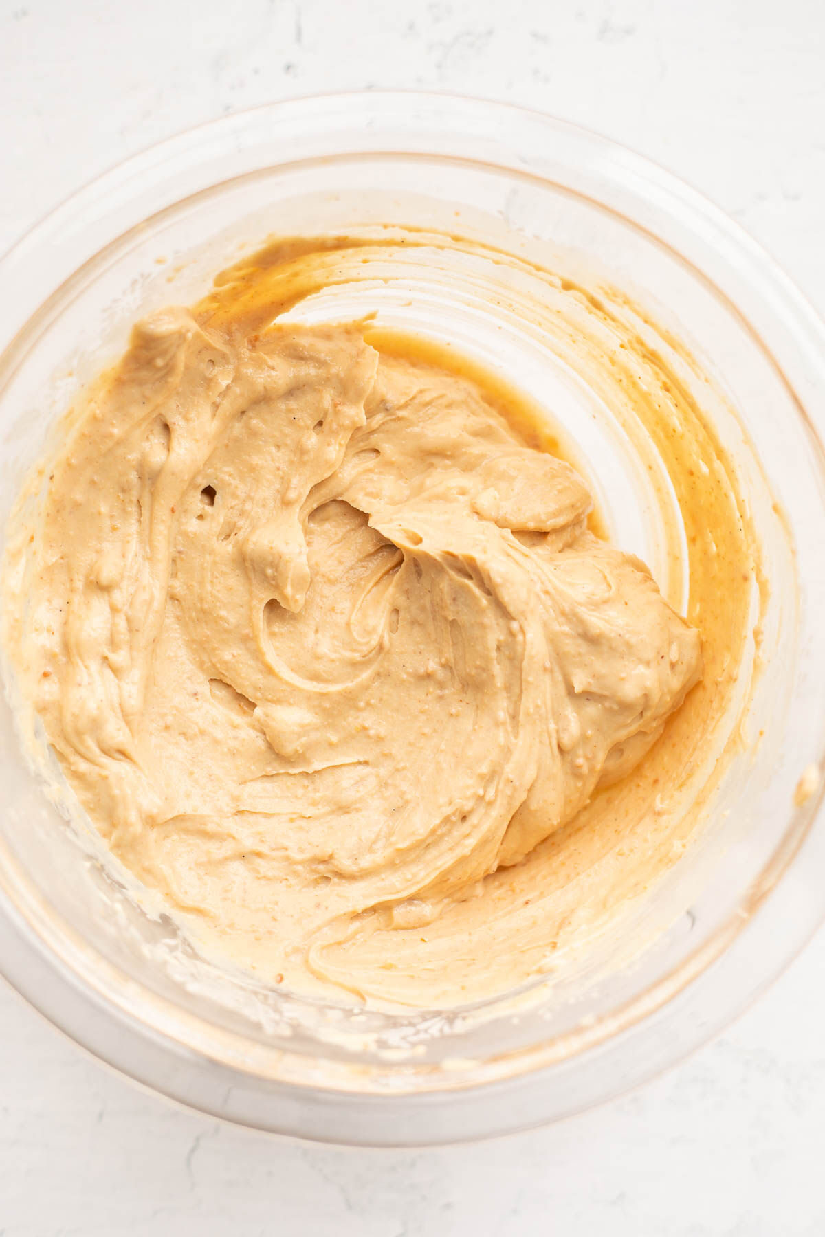 Wet ingredients for homemade protein bars in a glass bowl.