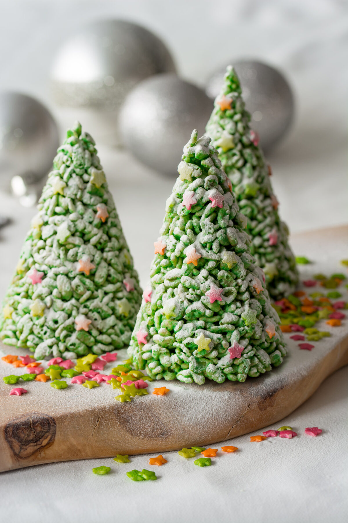 three rice krispies dusted with powdered sugar on a table. 