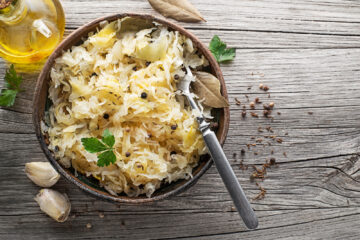 Homemade lacto-fermented sauerkraut in a brown bowl.