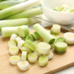 Leeks sliced up on a cutting board.