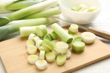 Leeks sliced up on a cutting board.