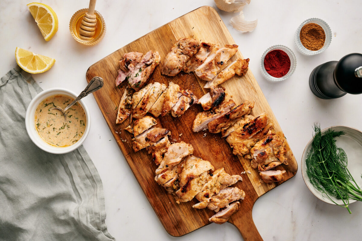 Lemon Dill Chicken cut up on a cutting board.