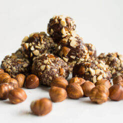 cropped imagae of nutella truffles with some hazelnuts