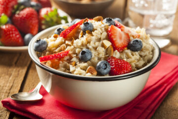 Healthy homemade oatmeal with strawberries and blueberries for breakfast.