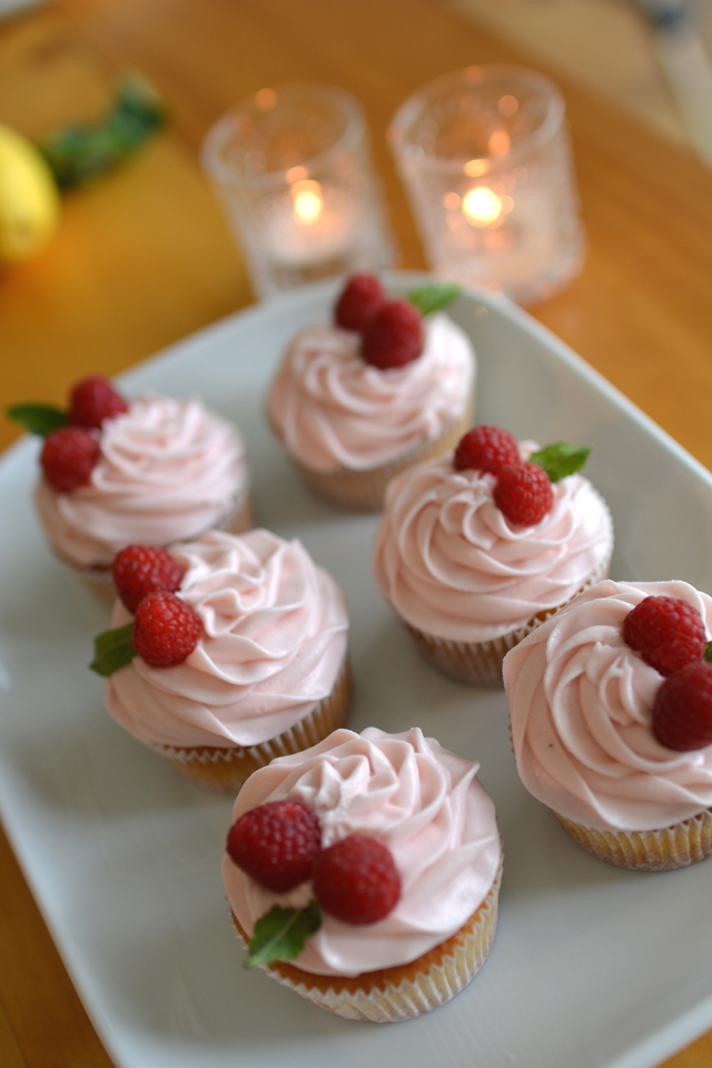 top view image of 6 lemon and raspberry cupcakes topped with fresh raspberries