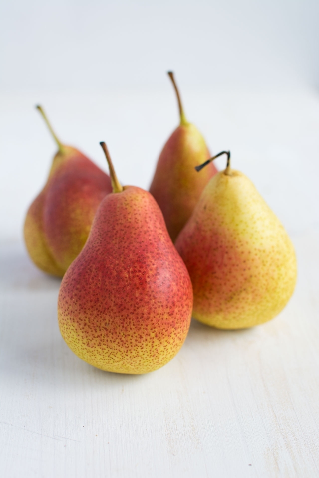 close-up image featuring four fresh pears
