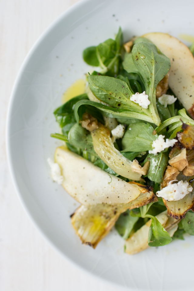 top-down half-view image of a plate featuring a visually appealing roasted fennel and pear salad
