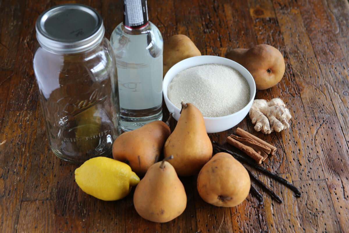 Ingredients for making pear liqueur on a wooden table.