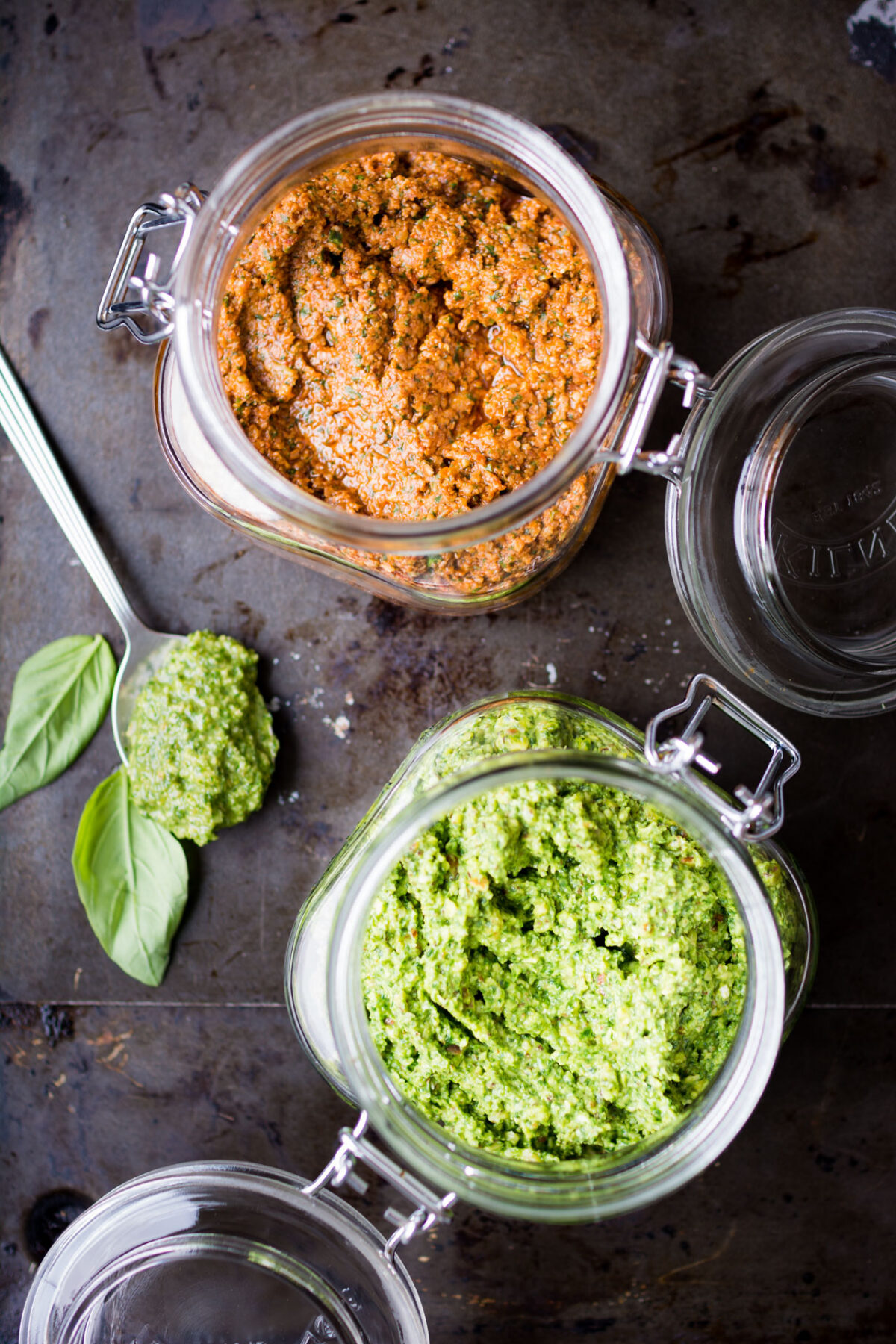 top down image of 2 jars containing classic basil pesto and sun dried tomato pesto