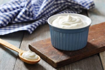 A cup of plain Greek yogurt in a ceramic ramekin.