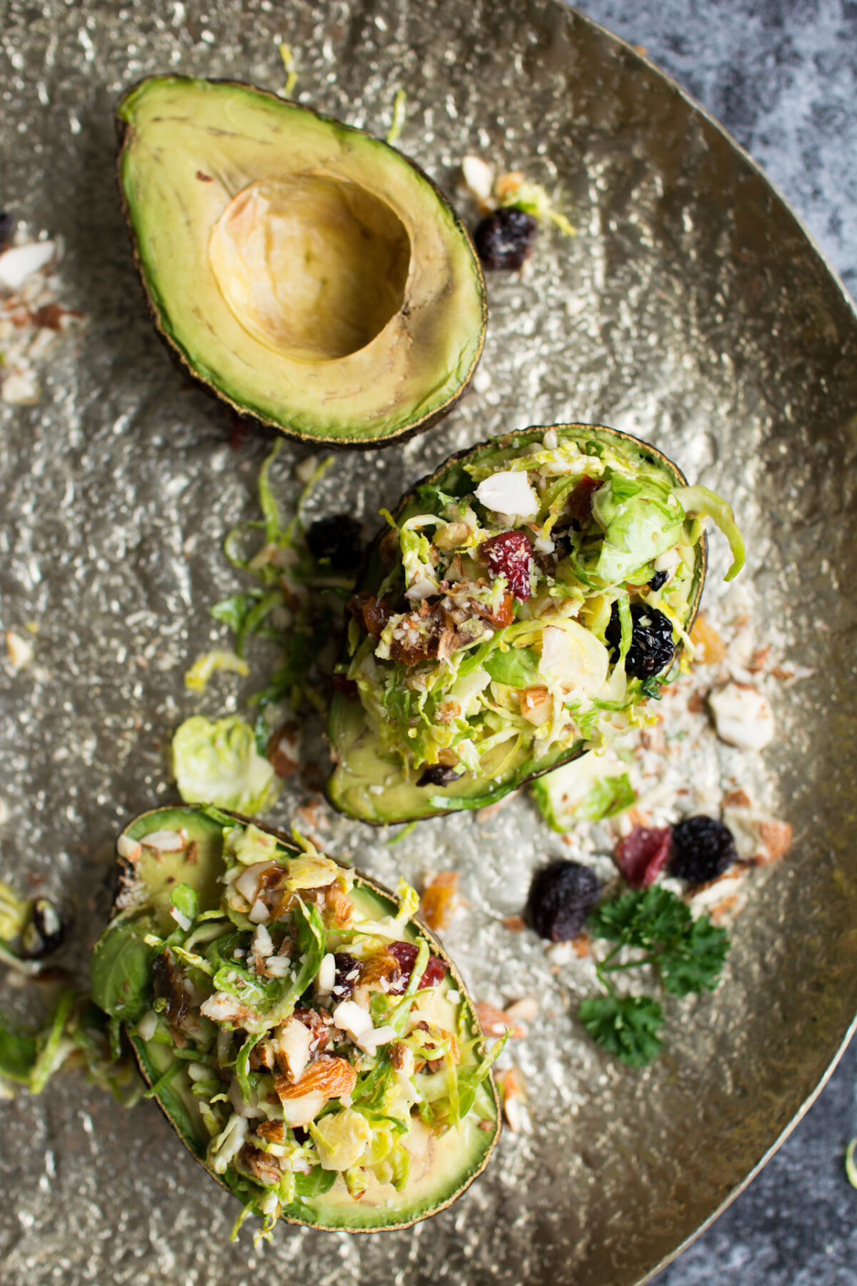 Raw Brussels Sprouts Salad with Dried Fruit served in a baked avocado!