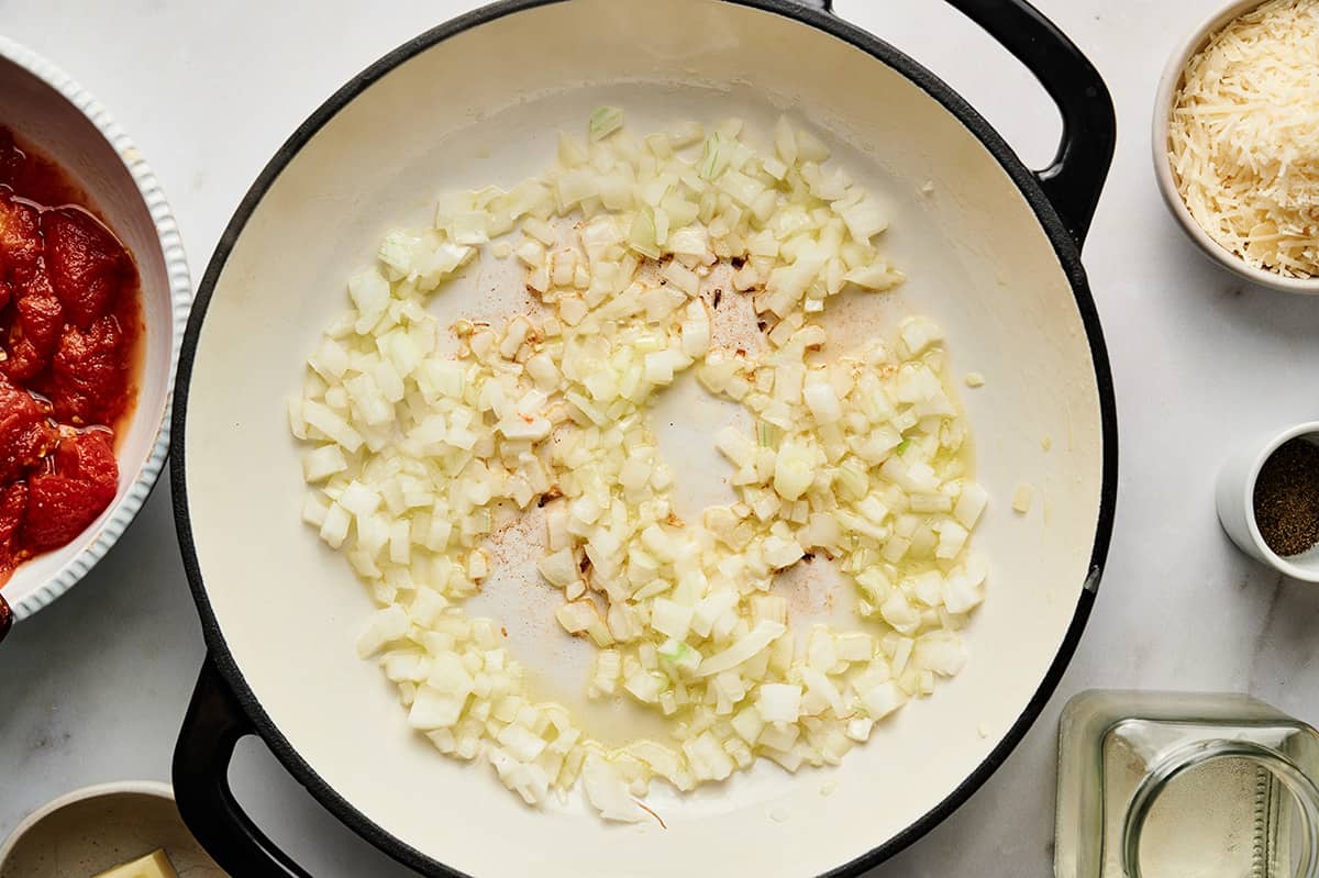 Sautéing onions in oil in a large pan.