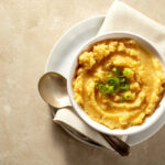 Root mash. Root vegetables mashed in a bowl. Garnished with oil and herbs.