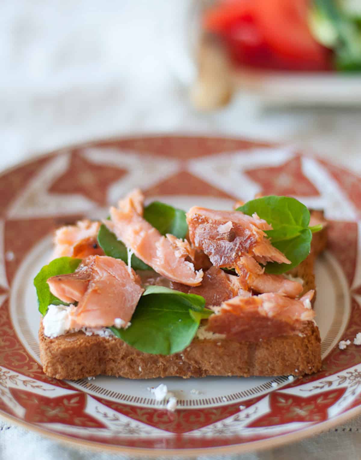 Hot smoked salmon on a slice of bread with goat cheese and watercress.