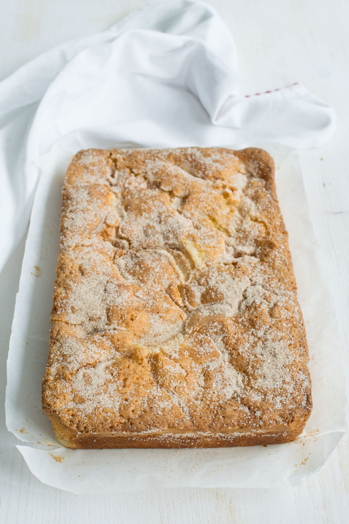 Top view image of a single layer of cinnamon spiced pear cake topped with caster sugar.