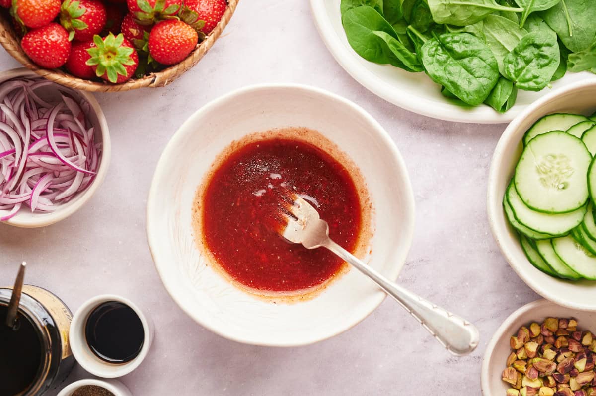 Strawberry vinaigrette in a white bowl with a fork.