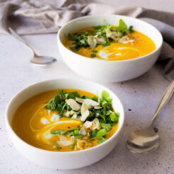 Spicy sweet potato soup served in two white bowls.