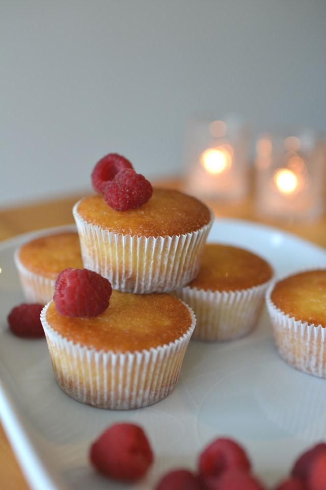 an image of cooked lemon and raspberry cucpcakes without icing with  fresh raspberries 