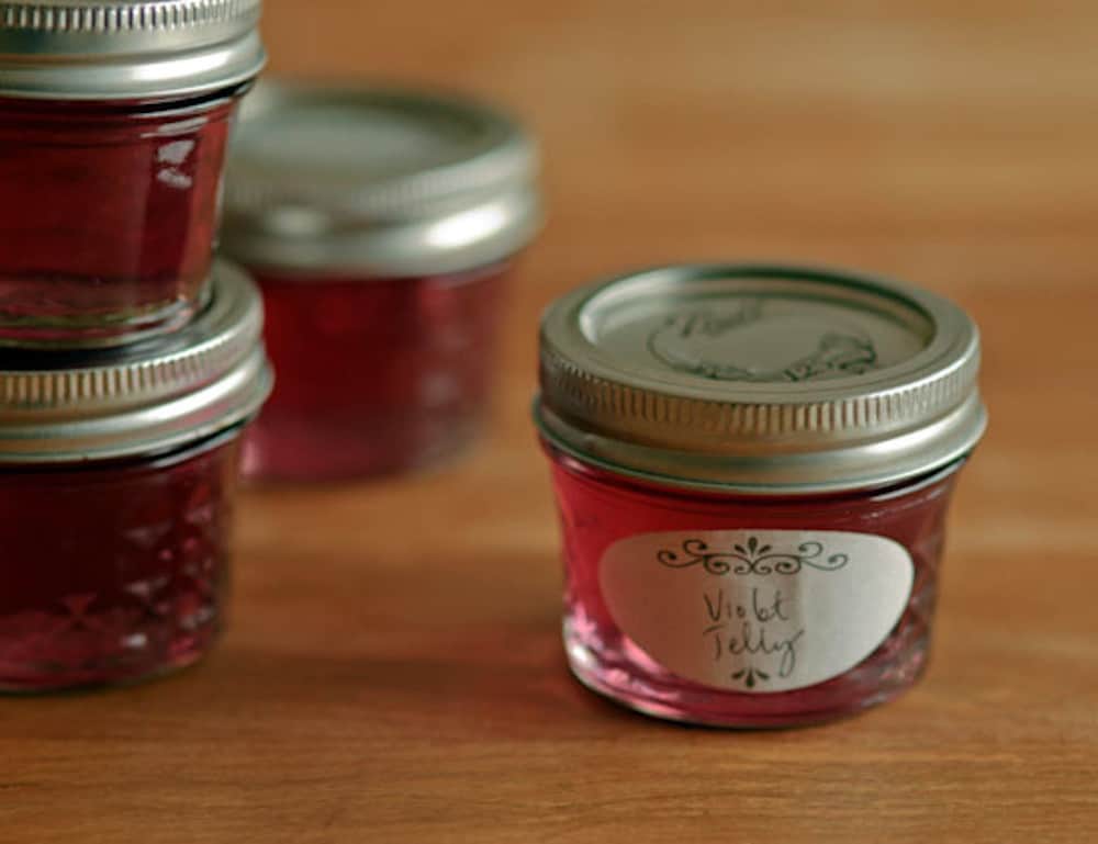 Jars of violet jelly with handwritten labels that read "Violet Jelly".